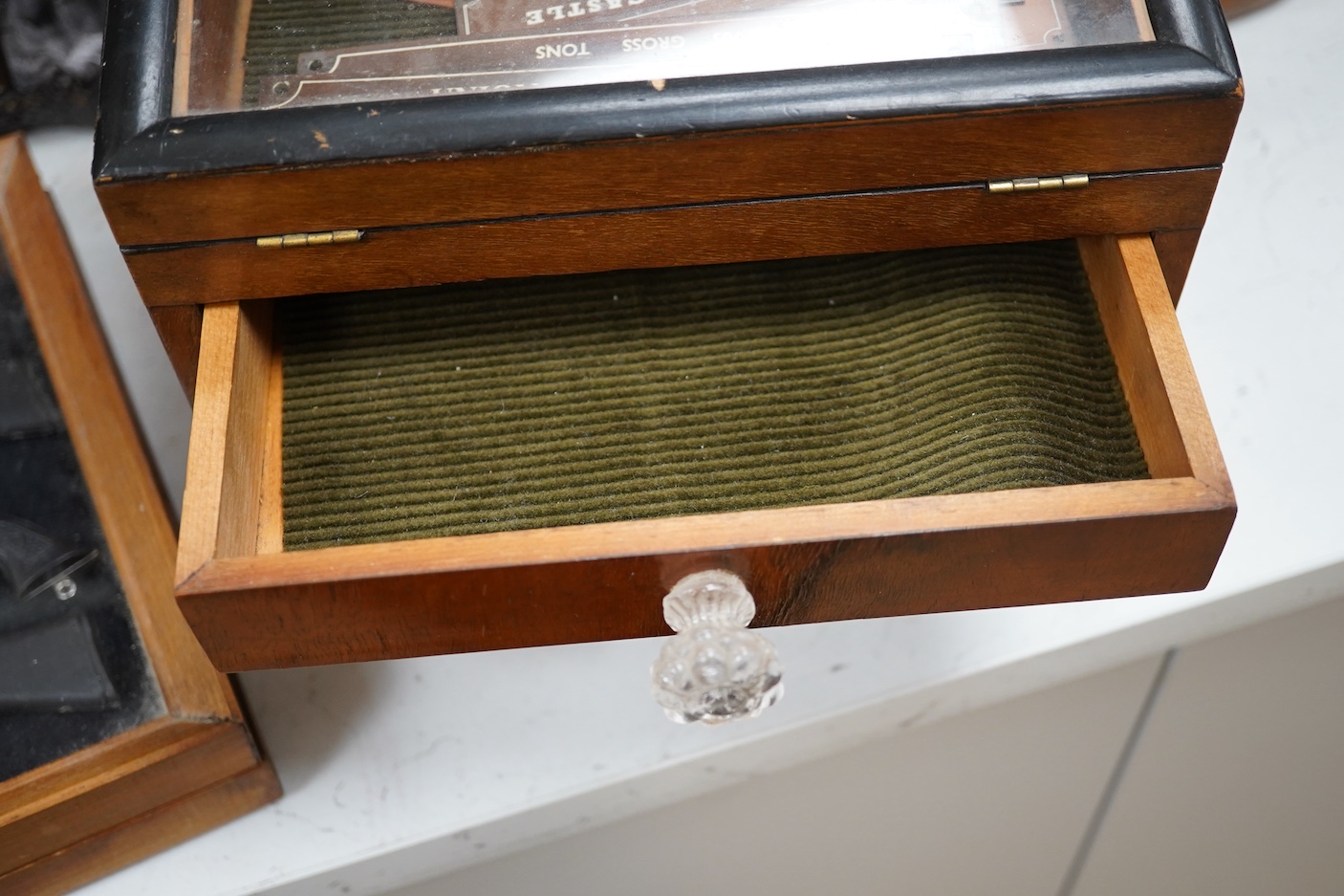 Sundry items comprising a small figured walnut table top collectors cabinet, a display case containing miniature rifles and pistols, a collection of copper and brass miniature RMS nameplates
